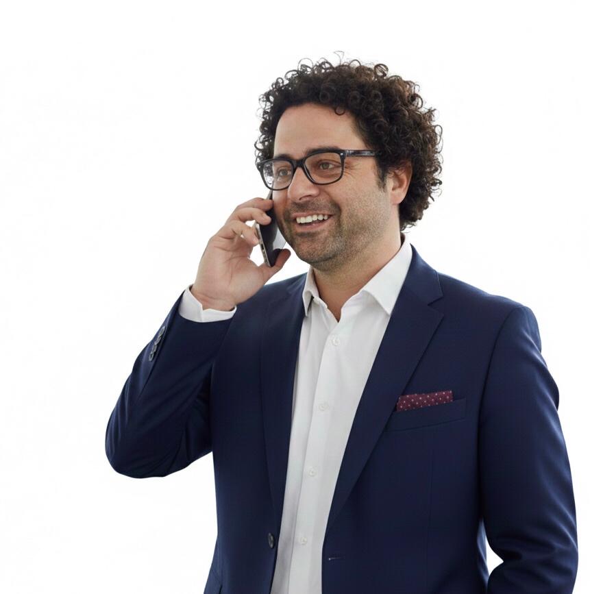 Ein lächelnder Fachberater mit Brille und dunkelblauem Sakko führt ein Beratungsgespräch am Smartphone.